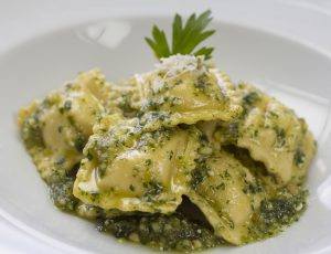 Italian raviolis stuffed with ricotta cheese, spinach and served with pesto sauce and grated parmesan cheese.